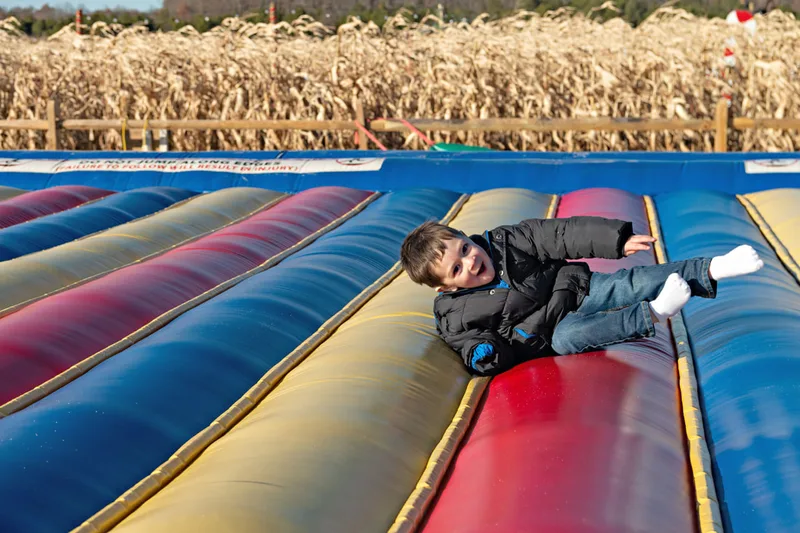 photo of a toddler boy jumping on a jump pad
