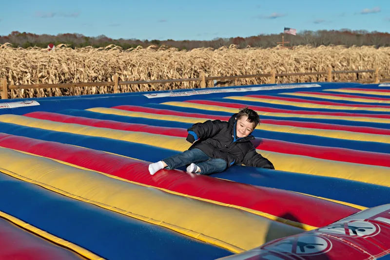 photo of a toddler boy jumping on a jump pad