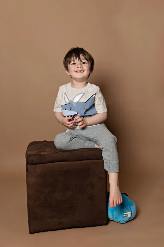 Toddler boy wearing a shirt with a shark dressed as an Easter bunny smiling at the camera