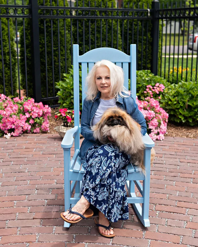 photo of a white woman with a Pekingese dog on her lap