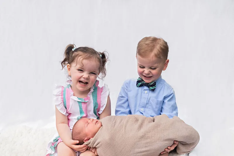 photo of toddler twins, a boy and a girl, and a newborn baby boy