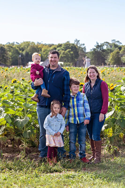 Family of 5 posing in a sunflower field on long island. Photo by Laura Pea Photography