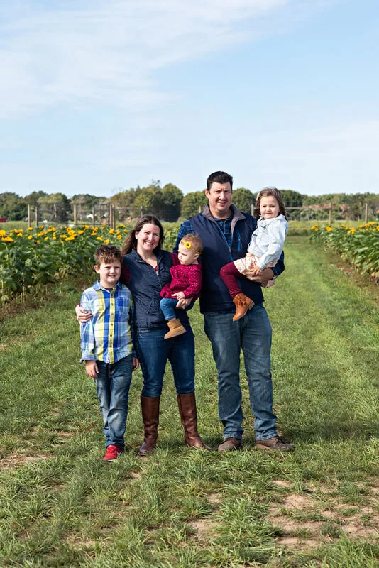 Family of 5 posing in a sunflower field on long island. Photo by Laura Pea Photography
