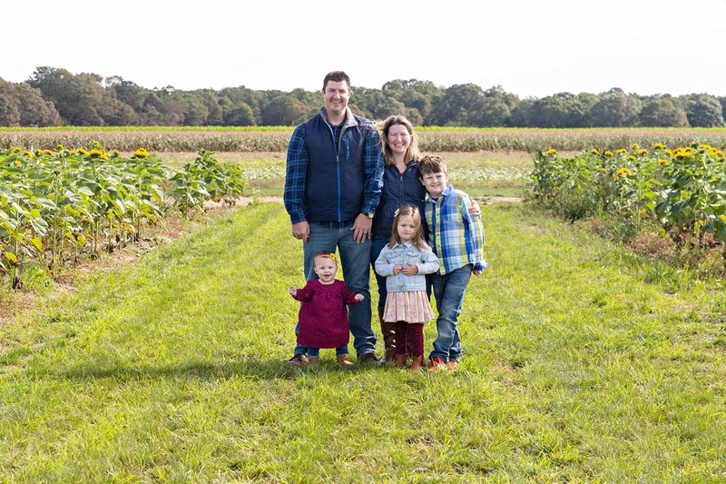 Family of 5 posing in a sunflower field on long island. Photo by Laura Pea Photography