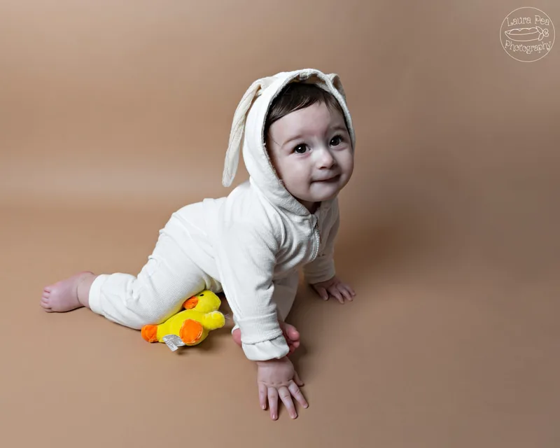 picture of baby boy's first easter photo session in an easter bunny costume crawling with stuffed baby chick