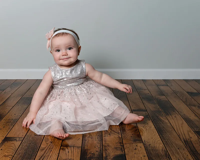 One year old girl first birthday photo in pink and silver sequin dress