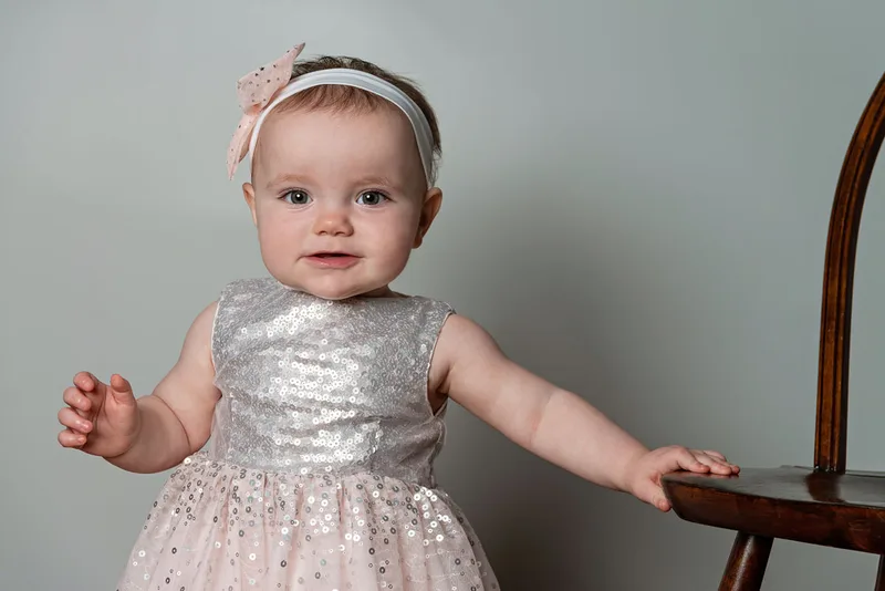One year old girl first birthday photo silver and pink sequin dress close up