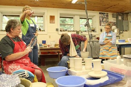 Antoinette Badenhorst demonstrating porcelain wheel throwing to potters before they practice at their wheels.