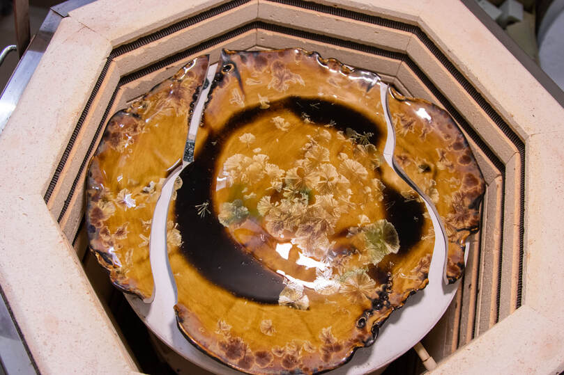 A golden crystalline plate that broke in 3 pieces due to uneven firing. 