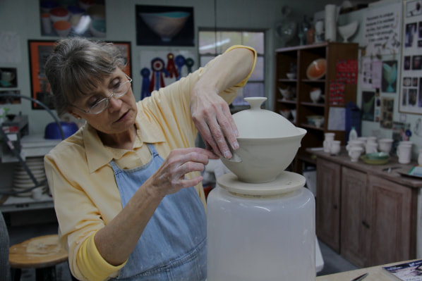 Antoinette adds the handles of the porcelain casserole that she made during the recording of the Wheelthrown Porcelain Dinnerware online workshop at TeachinArt. 