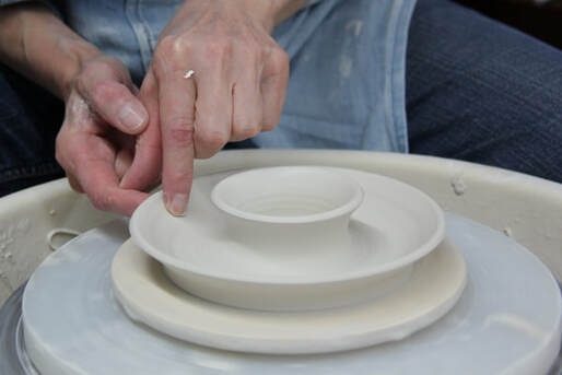 Throwing a double wall to form a candle stick holder. Antoinette Badenhorst explains how she uses porcelain clay to make collectable dinnerware for the kitchen. 