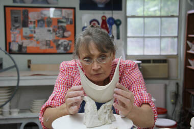 Antoinette evaluates the balance and form of a handbuilt porcelain bowl. Design and individual artistic development are an important part of her porcelain workshops.
