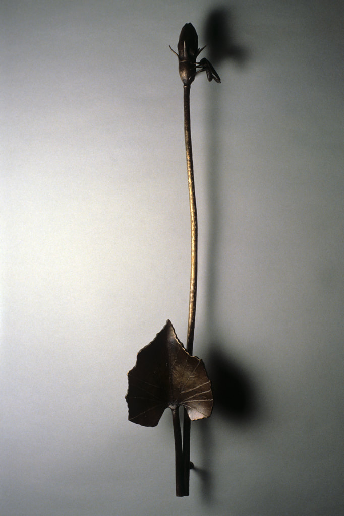 bronze sculpture of insect and plant