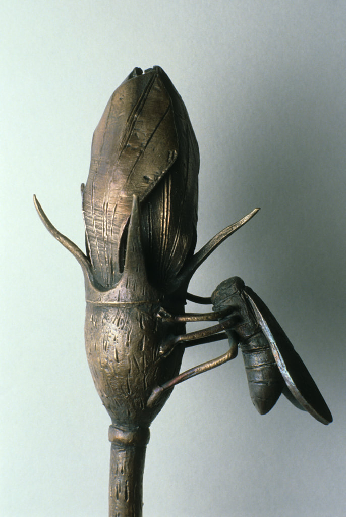 bronze sculpture of insect and plant