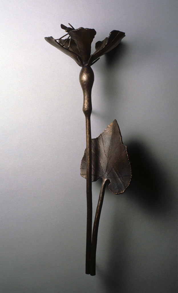 bronze sculpture of insect and plant