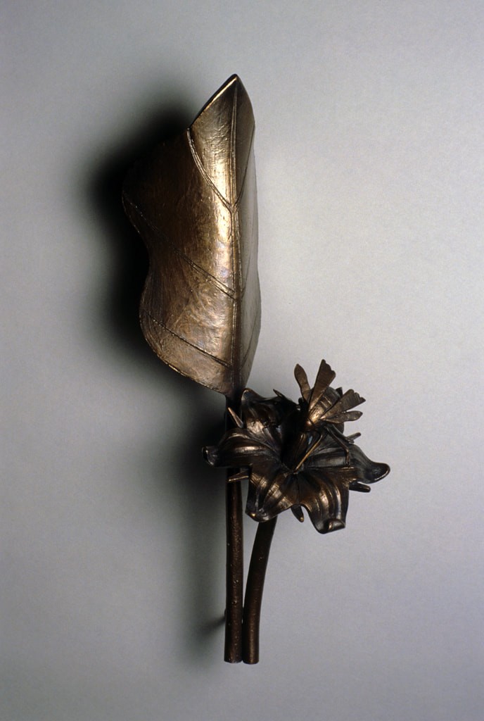 bronze sculpture of insect and plant