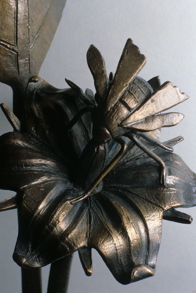 bronze sculpture of insect and plant