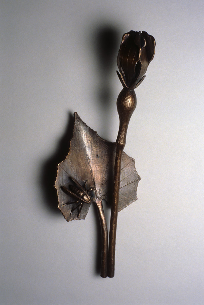 bronze sculpture of insect and plant