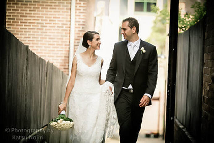 bride and groom smiling holding hands