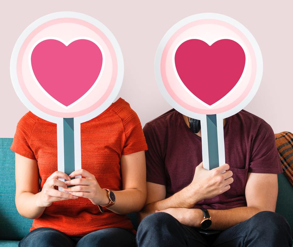 man and woman holding hearts over faces