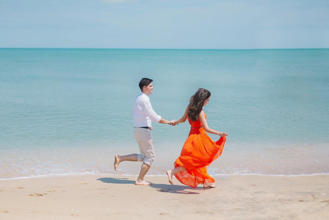 man and woman running on beach