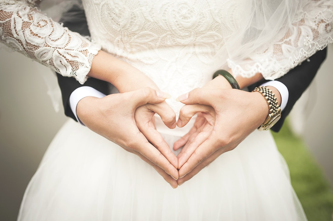 wedding couple making hearts with hands