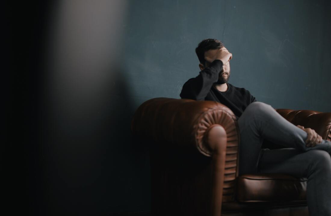 man holding head in hand