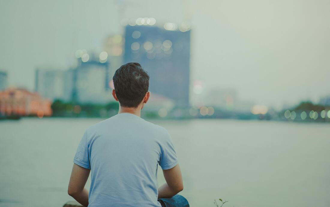 Man sitting looking at water
