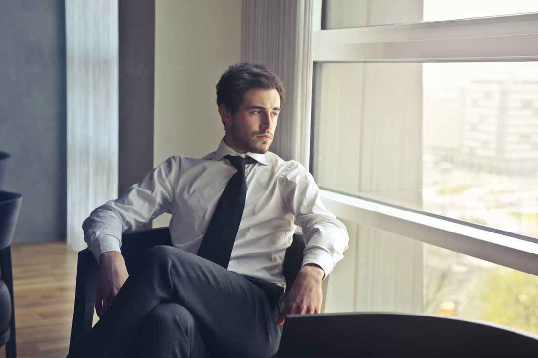 man sitting looking out a window