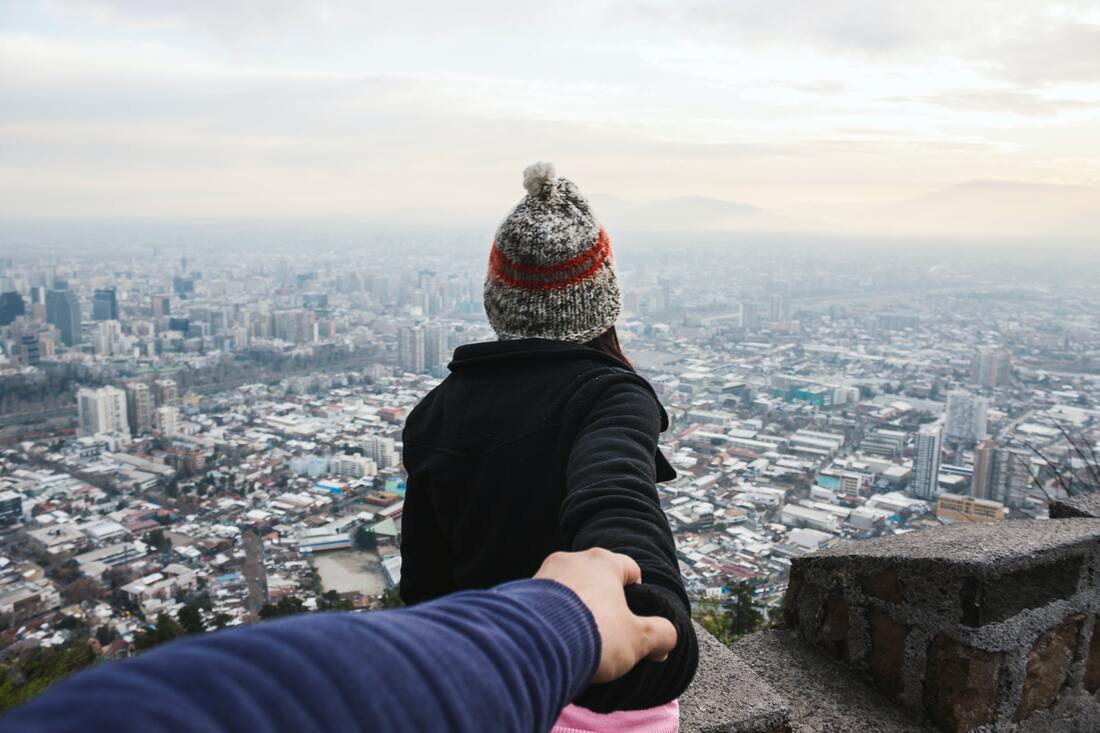 man holding womans hand as she looks forward