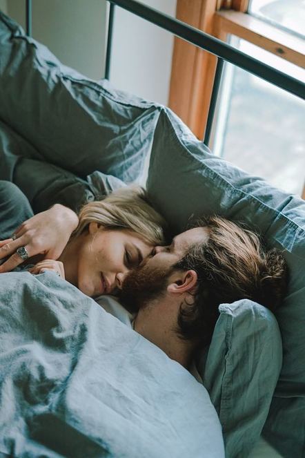 man and woman lying in bed