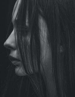Close up black and white photo of the side of a woman's face. This woman represents an adult who came for online counseling to heal her childhood trauma and complex PTSD. Maggie Jones Boyle offers online counseling for adults in Lawrence, Kansas.