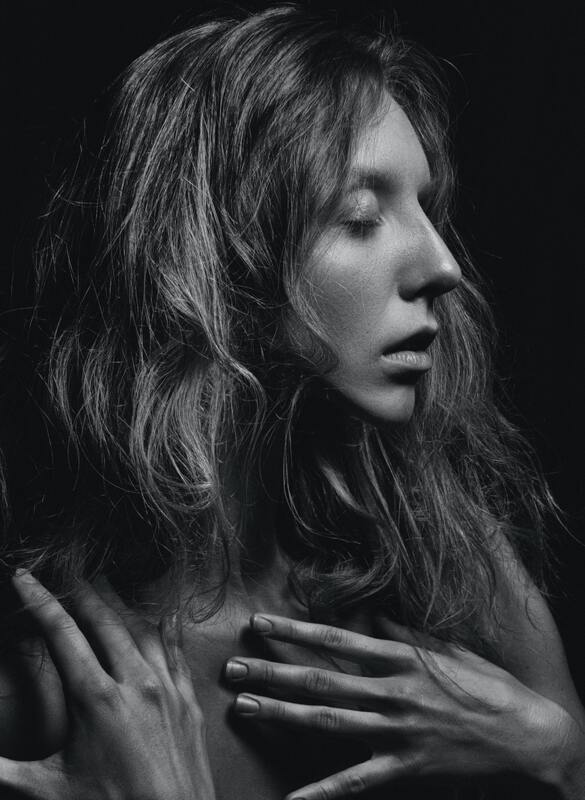Black and white portrait of a young white woman with her eyes closed and her hand over her chest. This represents that Sacred Circle Holistic Healing specializes in online therapy for young adults who identify as Highly Sensitive People.