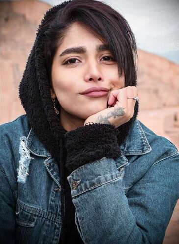Young woman looking into the camera representing a client in Lawrence Kansas coming to therapy for childhood trauma. 