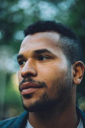 Young black man looking off camera. This illustrates that codependency effects people of different genders and ethnicities.