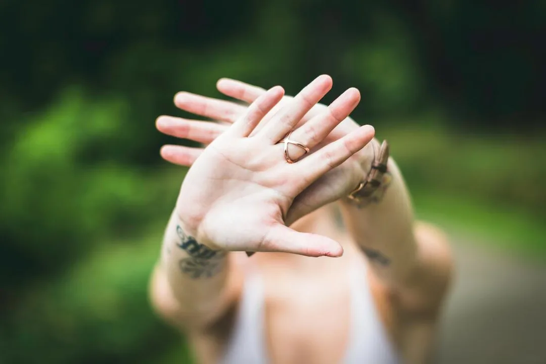 Photo of woman block face with hands out stretched toward camera. This illustrates setting a boundary. Maggie Jones Boyle is a therapist in Lawrence, Kansas specializing in codependency, anxiety, and low self-esteem.