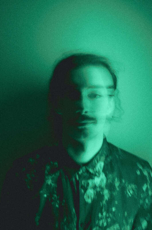 Young man with a ponytail looking at the camera. The photo is blurred and this illustrates the nature of psychological wounds and childhood trauma. Maggie Jones Boyle offers therapy in Kansas for childhood trauma, self-worth, and anxiety.