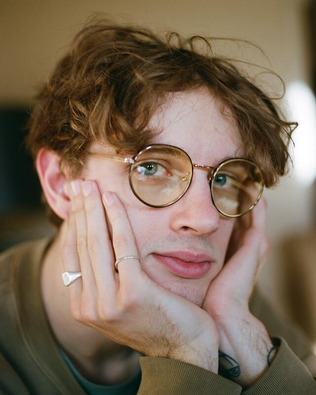 Portrait of a white man with glasses holding his face in this hands staring into the camera with a serious expression on his face. This illustrates that Highly Sensitive People are deep feelers and deep thinkers. Sacred Circle Holistic Healing specializes in counseling for Highly Sensitive People and empaths. 
