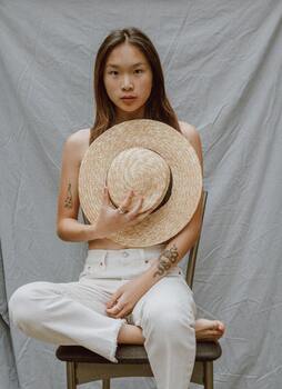 Woman sitting on a chair, staring to the camera. This illustrates being present with ourselves during difficult emotions. Sacred Circle Holistic Healings offers therapy for adults in Kansas struggling with anxiety and low self-esteem.