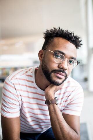 Portrait of a Black man with a nose piercing and glasses. This represents that Sacred Circle Holistic Healing specializes in therapy for highly sensitive people in Lawrence, Kansas.
