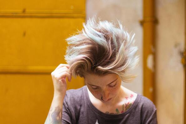 Young woman with short blonde hair looking down. This represents that Sacred Circle Holistic Healing offers online therapy in Kansas for Highly Sensitive People.
