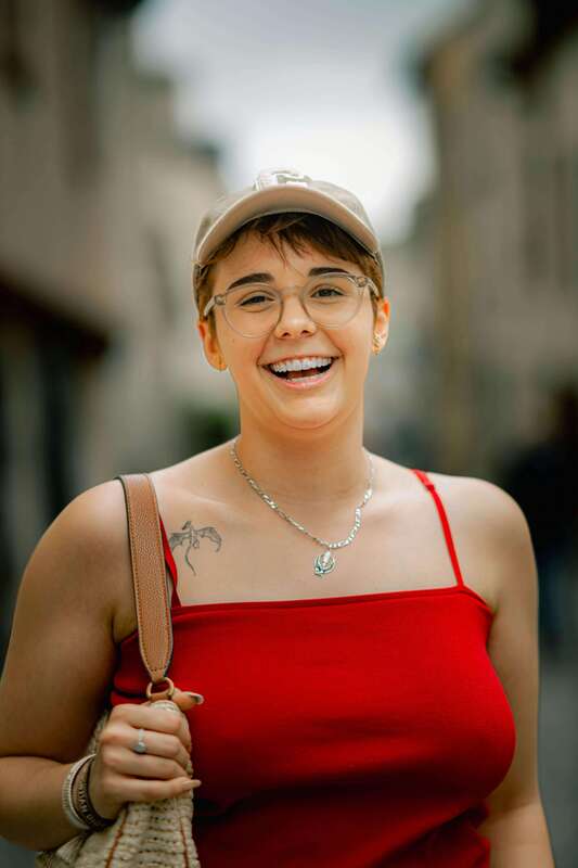 Smiling woman in city street. Example of who may come for therapy for compulsive people-pleasing.