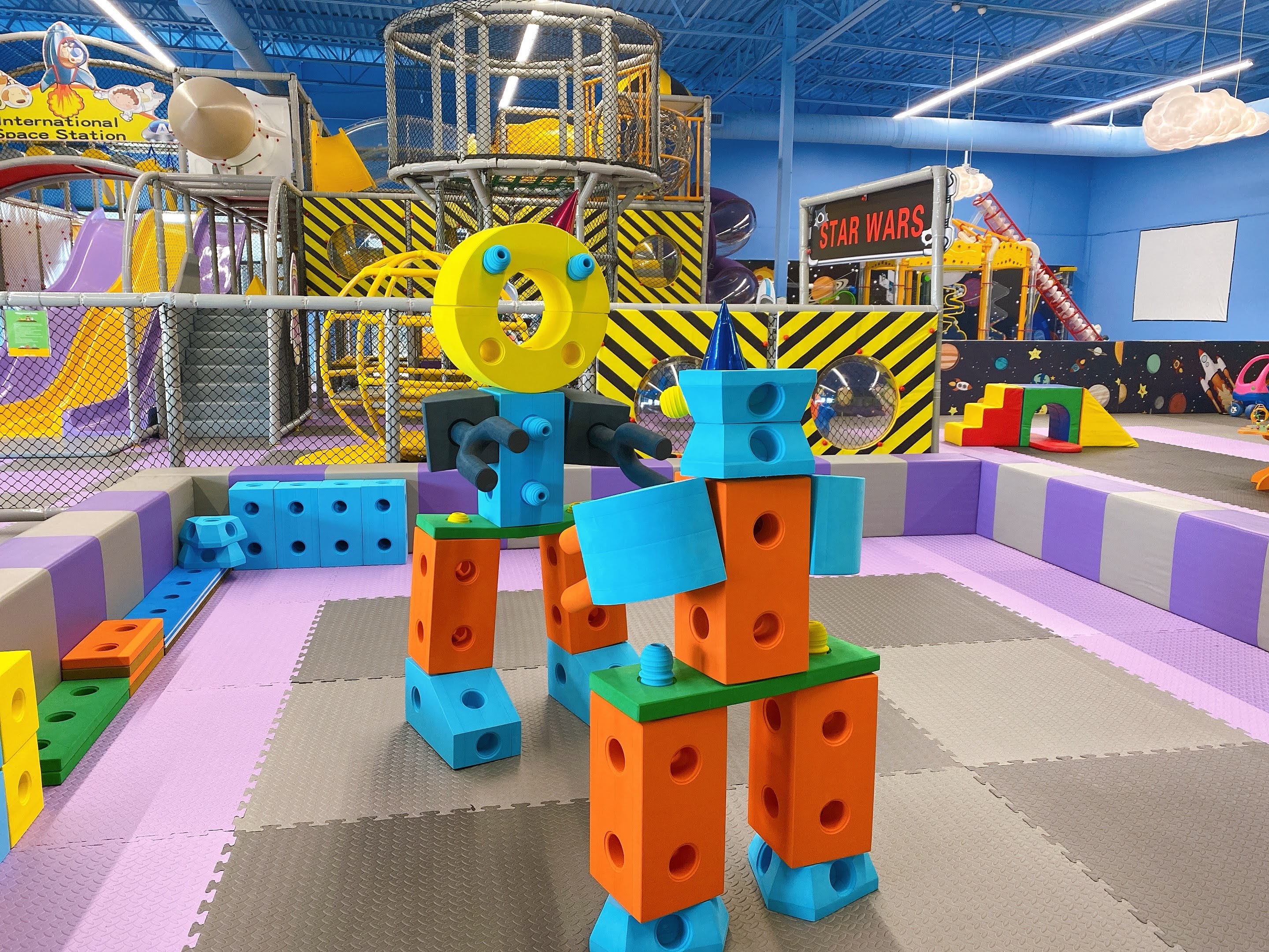 Colorful soft-block creations in front of the climbing structures and slides at Smarty Sprouts Kids’ Club.