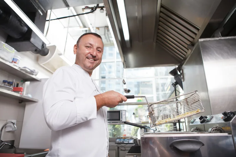Chef frying chips in a kitchen