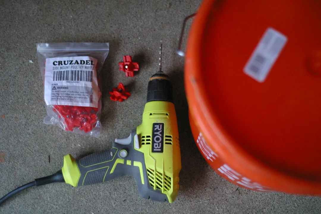 Supplies needed to make a DIY chicken waterer: 5 gallon bucket, drill, plastic side mount nipple