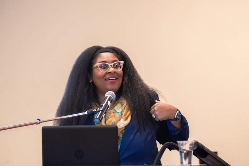 Dr. LaNysha Adams delivering a keynote at the microphone