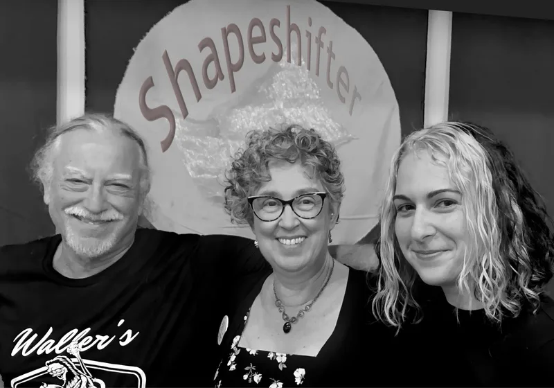 Dave, Robbin and Corinne in front of the Shapeshifter logo