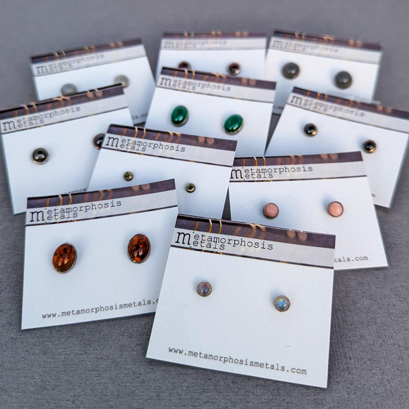 assorted bezel set stone stud earrings on display cards