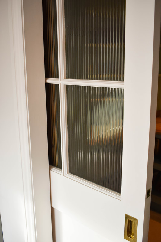 Readed glass pantry doors in kitchen in North London