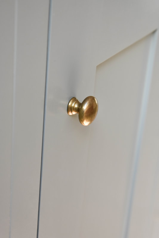 Antique brass knobs in handmade shaker kitchen in North London